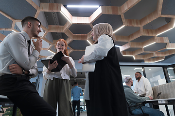 Image showing Young group of business people brainstorming together in a startup space, discussing business projects, investments, and solving challenges.