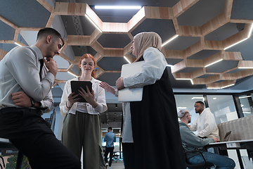 Image showing Young group of business people brainstorming together in a startup space, discussing business projects, investments, and solving challenges.