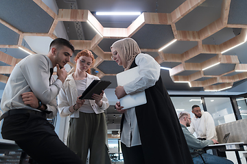 Image showing Young group of business people brainstorming together in a startup space, discussing business projects, investments, and solving challenges.