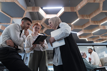 Image showing Young group of business people brainstorming together in a startup space, discussing business projects, investments, and solving challenges.