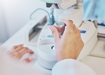 Image showing Ophthalmology, test and hand of a doctor on a machine for a consultation, vision check and monitor lens. Medicine, healthcare and optician moving a handle on equipment for analysis of eyes and retina