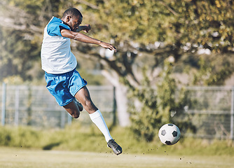 Image showing Sports, soccer and man in action with ball playing game, training and exercise on outdoor field. Fitness, workout and male football player kicking, running and score goals, winning and competition