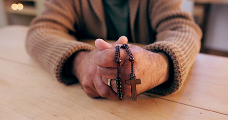 Image showing Hands, rosary and cross with closeup for faith, peace and hope at desk, home or praying for worship. Person, crucifix and jewelry for religion, mindfulness and connection to holy spirit, Jesus or God