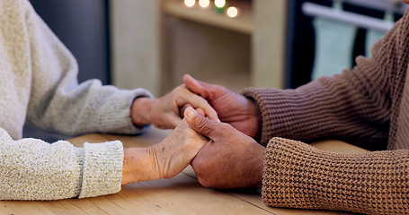 Image showing Couple, holding hands and closeup for praying in home with faith, religion and hope for peace at desk. People, prayer and together with support, empathy and care with worship for connection to God