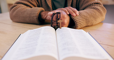 Image showing Hands, rosary and bible with closeup for faith, peace and hope at desk, home or praying for worship. Person, cross and jewelry for religion, mindfulness and connection to holy spirit, Jesus or God