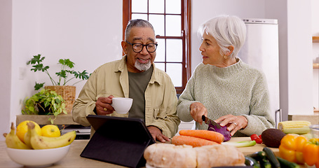 Image showing Senior couple, cooking and tablet in home kitchen with knife, vegetables and tea cup for conversation. Interracial marriage, elderly woman and old man with touchscreen for video, food and nutrition