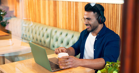 Image showing Happy man in coffee shop with headphones, laptop and remote work, reading email and internet in restaurant. Computer, freelancer and copywriter in cafe, listening to music and drink in cup at table