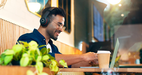Image showing Happy man in cafe with headphones, typing on laptop and remote work, reading email and web in restaurant. Computer, freelancer smile and copywriter in coffee shop, listen to music and radio at table