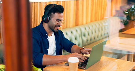 Image showing Happy man in cafe, typing on laptop and music for remote work, reading email and writing. Computer, freelancer and editor in coffee shop, headphones and listening to radio, podcast or audio at table