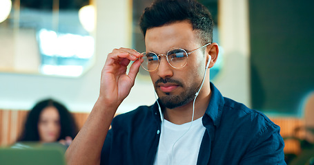 Image showing Man, reading glasses and cafe for online research, remote work and review of website and analysis. Freelancer worker or designer in coffee shop or restaurant with computer and music for internet info