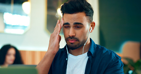 Image showing Man, headache and pain at cafe for online research, planning and remote work stress, deadline or mistake. Frustrated freelancer listening to music with migraine, mental health and tired in restaurant