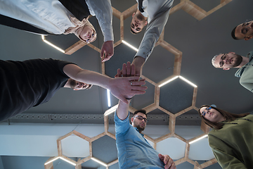 Image showing A group of young businessmen offer their hands together, symbolizing togetherness in the business world