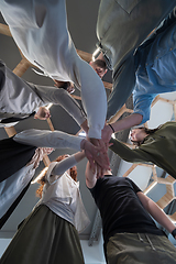 Image showing A group of young businessmen offer their hands together, symbolizing togetherness in the business world