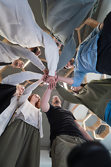 Image showing A group of young businessmen offer their hands together, symbolizing togetherness in the business world