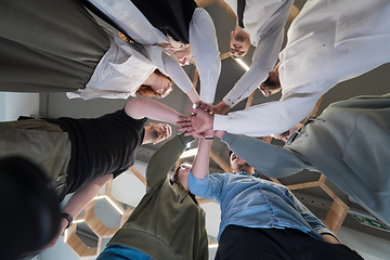 Image showing A group of young businessmen offer their hands together, symbolizing togetherness in the business world