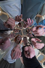 Image showing In a modern office, a group of young business professionals is captured in a warm and embracing hug, reflecting the spirit of unity, collaboration, and shared success in their dynamic workplace.