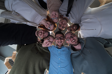 Image showing In a modern office, a group of young business professionals is captured in a warm and embracing hug, reflecting the spirit of unity, collaboration, and shared success in their dynamic workplace.