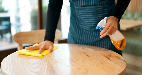 Image showing Waiter, hands and cleaning table in cafe for dust, bacteria and dirt with cloth, spray or detergent. Barista, person and wipe wooden furniture in coffee shop or restaurant with chemical liquid