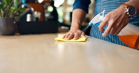 Image showing Waiter, hands and cleaning table in restaurant for dust, bacteria and dirt with cloth, spray or detergent. Barista, person or wipe wooden furniture in coffee shop or cafe with chemical liquid closeup