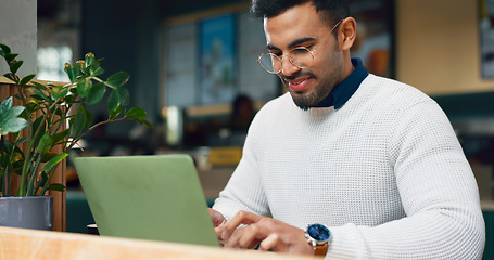 Image showing Man, typing and laptop in cafe for remote work, research or networking for business with smile. Face, person and happiness with technology in coffee shop for copywriting, internet and freelancer