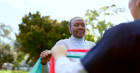 Image showing Senior, woman and nurse with stretching band outdoor for exercise, workout or fitness in a park. People, professional or caregiver or physical activity for physiotherapy, wellness or health in nature