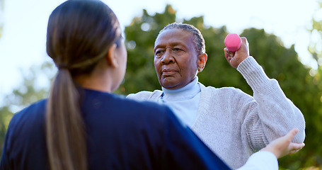 Image showing Dumbbell, exercise and a senior black woman with a nurse outdoor in a garden together for physiotherapy. Fitness, health or wellness with an elderly patient and medical nurse in the yard to workout