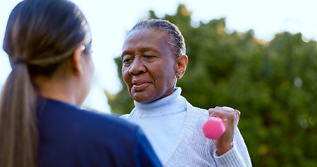 Image showing Dumbbell, fitness and a senior black woman with a nurse outdoor in a garden together for physiotherapy. Exercise, health or wellness with an elderly patient and medical person in the yard to workout