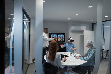 Image showing A diverse group of businessmen collaborates and tests a new virtual reality technology, wearing virtual glasses, showcasing innovation and creativity in their futuristic workspace