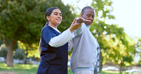 Image showing Elderly, woman and caregiver with arm stretching for exercise, workout or fitness in a park with smile. People, professional or nurse with activity for physiotherapy, wellness and health in nature