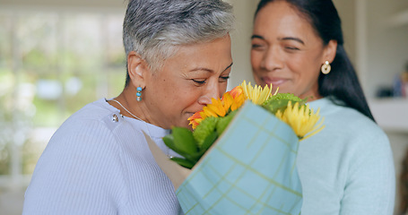 Image showing Love, flowers and mother and daughter in home for bonding, relationship and celebrate together. Family, happy and mature mom embrace adult woman for mothers day, support and birthday in living room