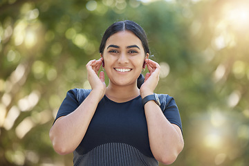 Image showing Music, fitness and woman with smile for earpods during training, exercise or running in a park. Podcast, motivation and portrait of an Indian runner happy during an outdoor workout in nature