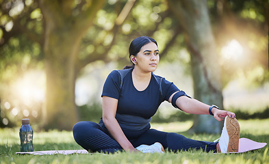 Image showing Woman, fitness stretching and nature park listening to music after a runner exercise and sports. Real plus size athlete from India stretch legs ready for wellness, health workout and running on grass