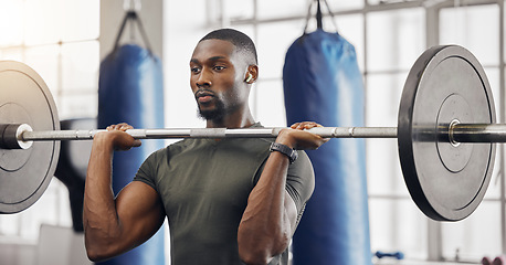 Image showing Earphones, barbell and black man training in gym while listening to music, radio or podcast. Energy, health and male bodybuilder from South Africa weight lifting while streaming audio or sound track.