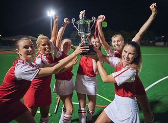 Image showing Winner, success and sport with hockey team, girl athlete on field celebrate and trophy after win. Celebration, fitness and teamwork, yes to victory and happy with diversity and sports achievement.