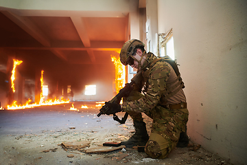 Image showing Soldier in action near window changing magazine and take cover