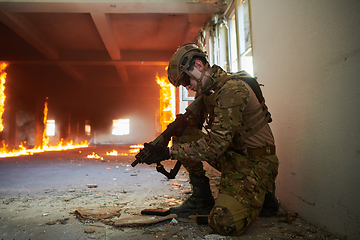 Image showing Soldier in action near window changing magazine and take cover