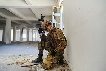 Image showing Soldier in action near window changing magazine and take cover