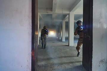 Image showing A group of professional soldiers bravely executes a dangerous rescue mission, surrounded by fire in a perilous building.