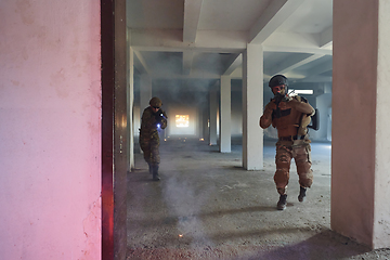 Image showing A group of professional soldiers bravely executes a dangerous rescue mission, surrounded by fire in a perilous building.