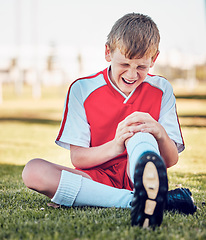 Image showing Soccer, knee injury and pain on a field after match, training or fitness exercise at stadium pitch. Sports, football and boy in a medical emergency with torn muscle, sprain or broken bone in his leg.