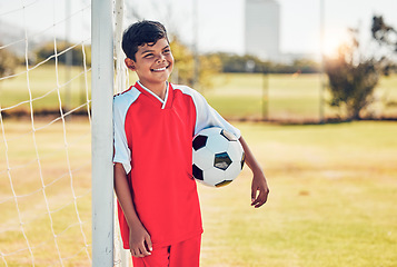 Image showing Soccer player, field and child with happy game, competition or training on pitch near goal post with fitness health. Kid with soccer ball thinking on a football field for exercise, workout or sports