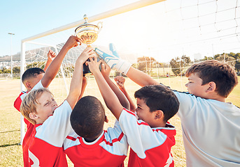 Image showing Children, sports and trophy with a winner team in celebration of victory on a field or grass pitch outdoor. Soccer, health and award with a kids group cheering their sport achievement outside
