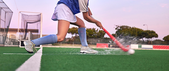 Image showing Hockey, stick and ball with a water splash on grass during exercise, training and fitness workout for a game, competition or match. Legs of athlete on sports field for goal, challenge and battle