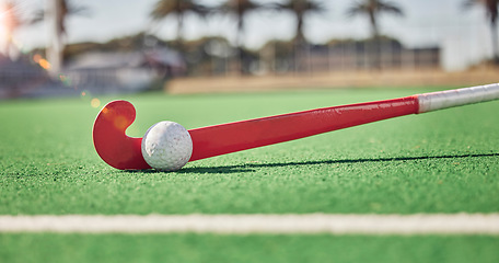 Image showing Closeup, hockey and hockey stick with ball on field in sunshine for sport, contest or competition in summer. Sports, turf pitch and artificial grass on ground for exercise, workout and training game