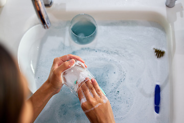 Image showing woman hands, cleaning dishes and water in sink in kitchen for clean home morning routine. Bacteria, dirty wine glasses and foam cleaner for health safety, maid, housekeeper and domestic lifestyle