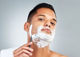 Image showing Man, razor and skincare in beauty for grooming, shave or clean hygiene against a grey studio background. Male face shaving beard with cream, cosmetics and care for healthy or fresh skin