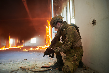 Image showing Soldier in action near window changing magazine and take cover