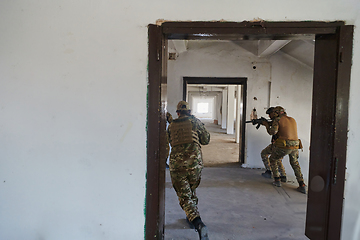 Image showing A group of professional soldiers bravely executes a dangerous rescue mission, surrounded by fire in a perilous building.