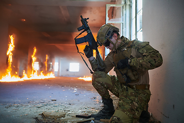 Image showing Soldier in action near window changing magazine and take cover