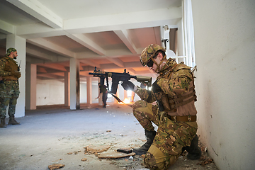 Image showing Soldier in action near window changing magazine and take cover